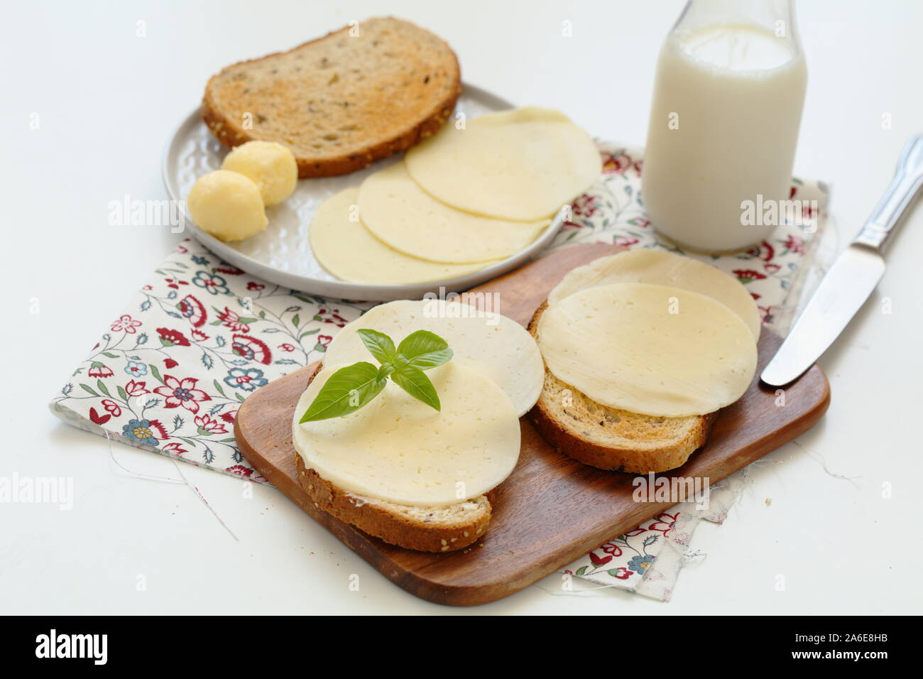 Toasts avec beurre d'agriculteurs et les tranches de fromage sur une planche à découper Banque D'Images