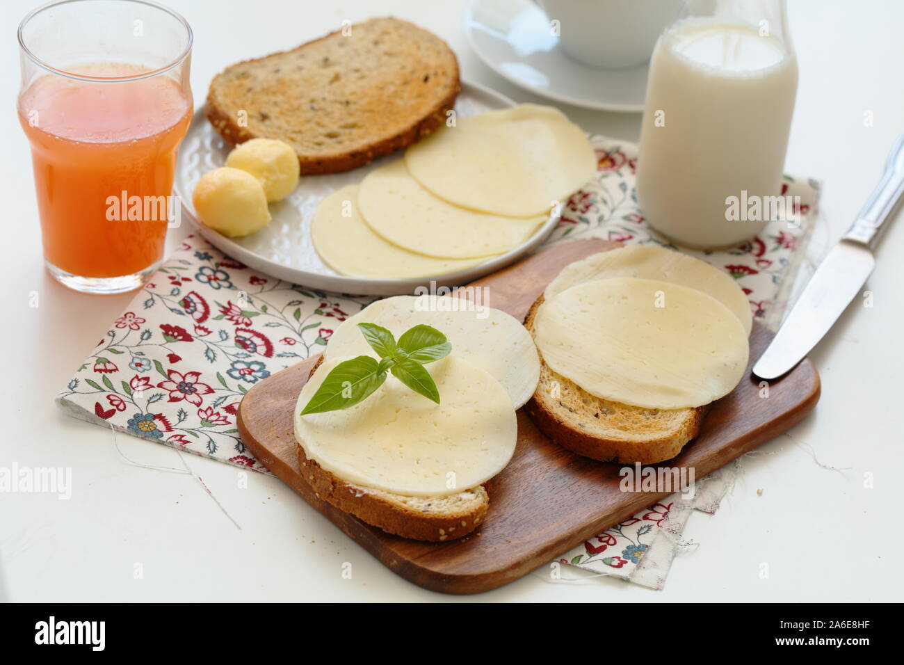 Toasts avec beurre d'agriculteurs et les tranches de fromage sur une planche à découper Banque D'Images