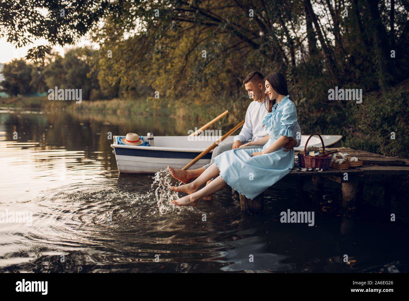 Love couple assis sur la jetée sur le lac tranquille Banque D'Images