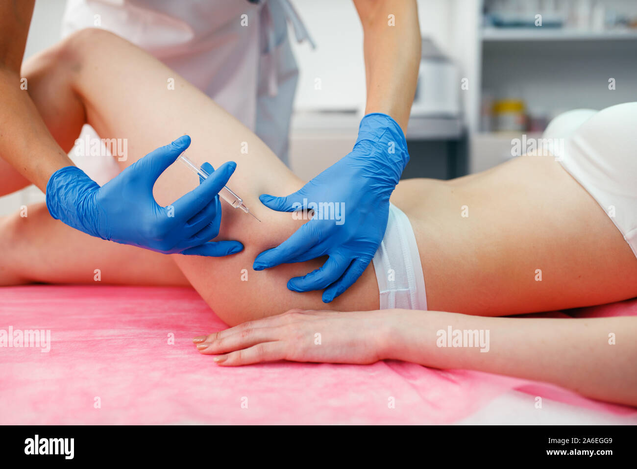 Cosmetician donne botox injection dans la cuisse Banque D'Images