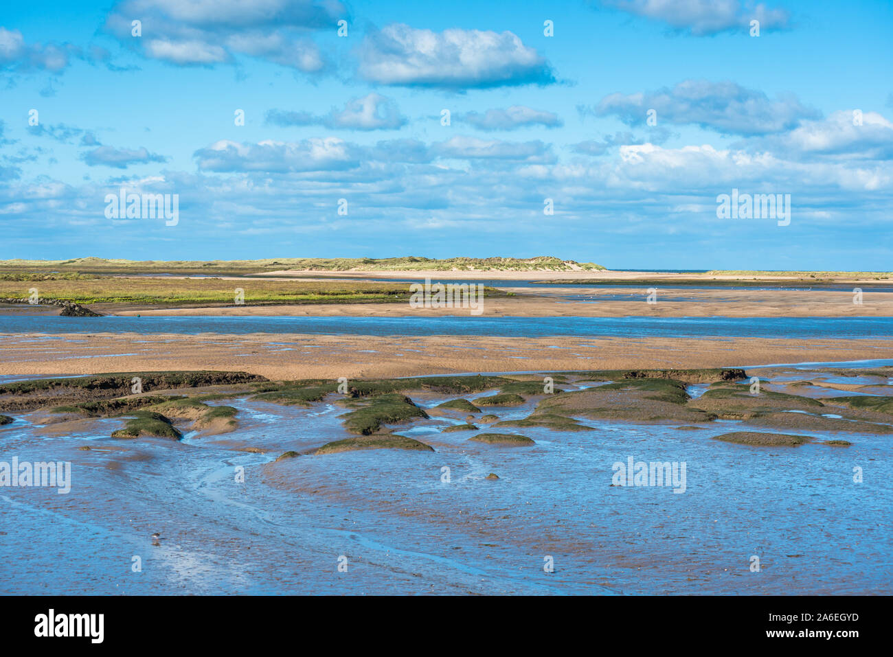 Vue sur la mudFlat à marée basse depuis le sentier national de la côte Norfolk, près de Burnham Overy Staithe, de l'île Scolt Head à l'arrière, East Anglia, Angleterre, Royaume-Uni. Banque D'Images