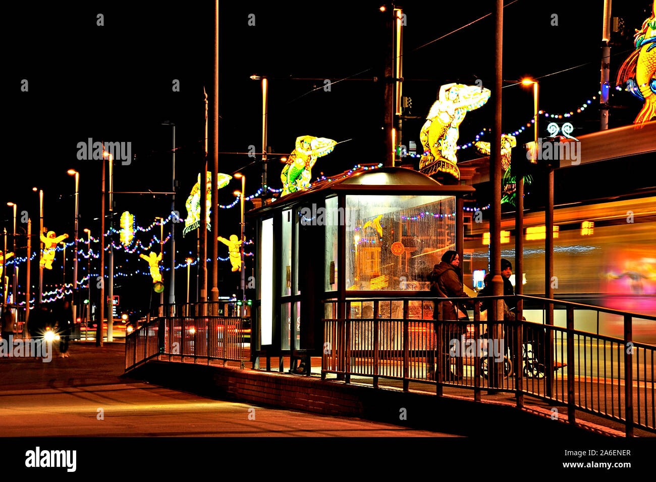 Light trails de tram s'arrête à l'abri à image des passagers sur le front au cours de l'Assemblée illuminations Banque D'Images