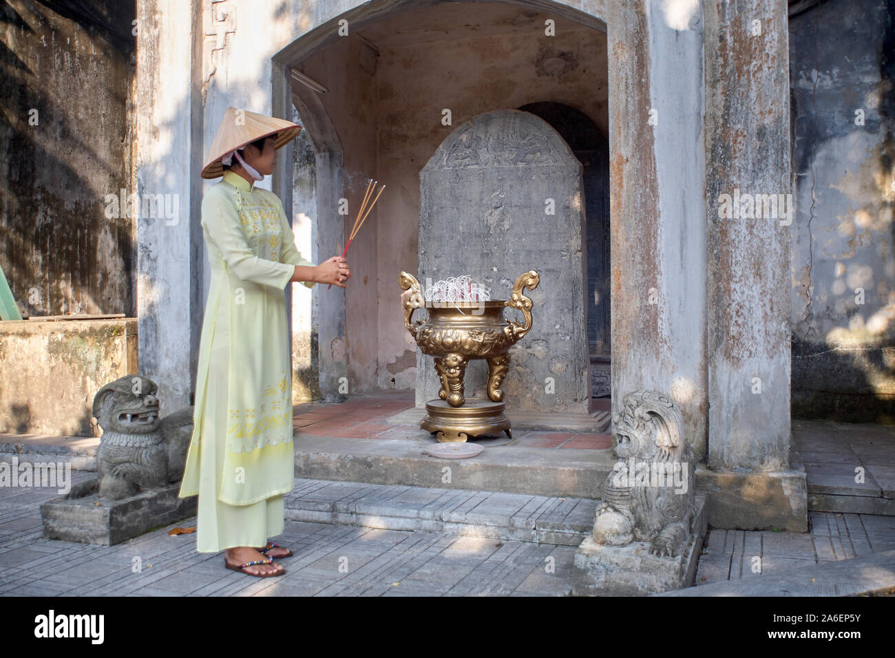 Femme portant robe traditionnelle vietnamienne et chapeau conique à un temple dans la province de Bac Ninh, Vietnam Banque D'Images