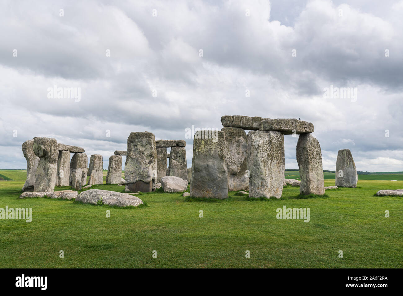 Stonehenge sur un jour de printemps, nuageux et venteux. Les ruines anciennes dans le Wiltshire, Angleterre, avec aucune personne ou les touristes. Au premier plan de l'herbe verte Banque D'Images