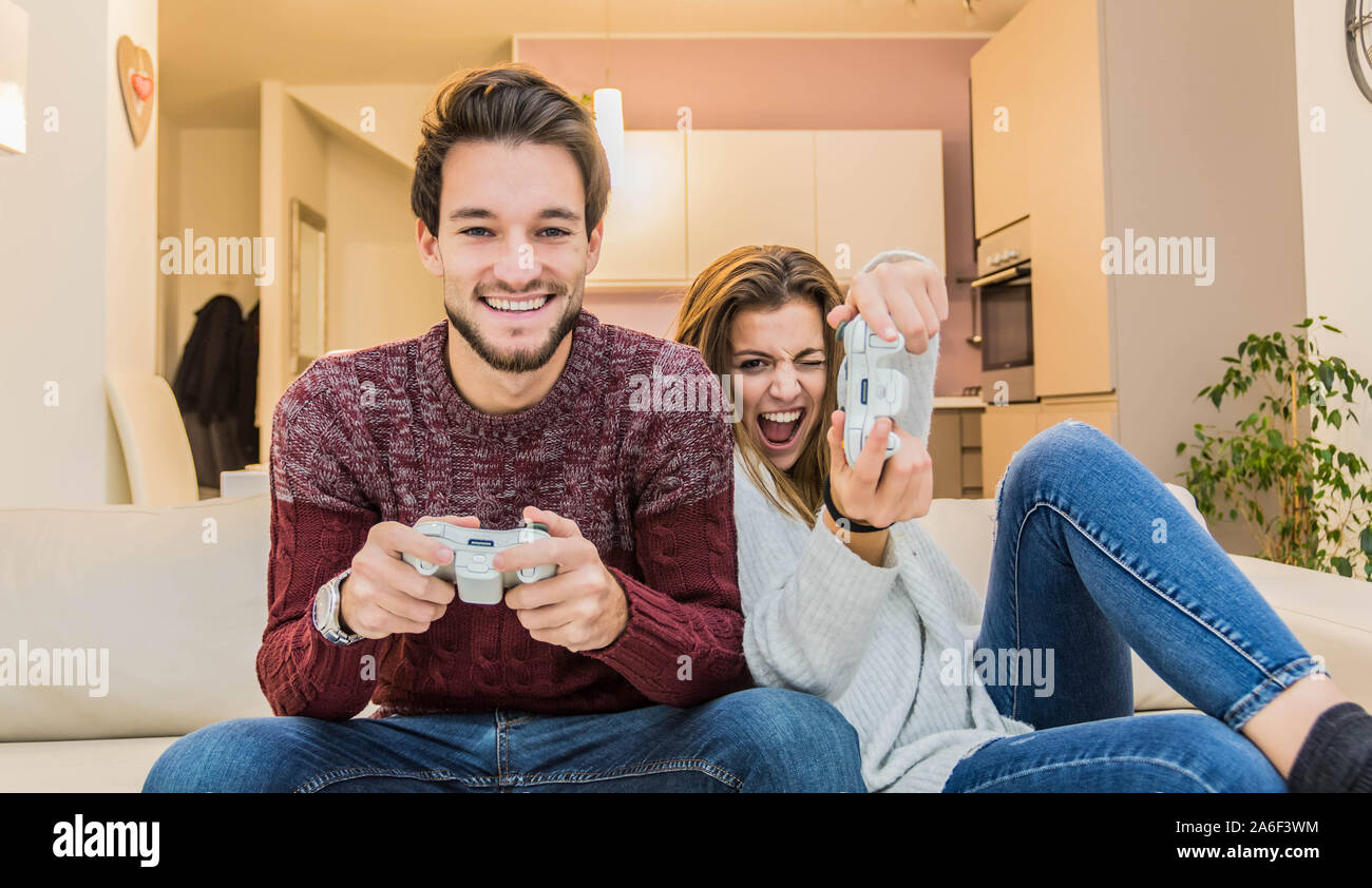 Jeune couple ayant l'amusement jouer le jeu vidéo à la maison. Banque D'Images
