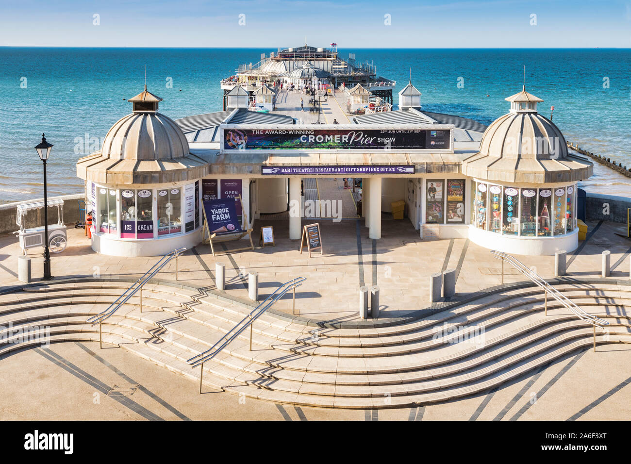 22 Juin 2019 : Cromer, Norfolk, UK - l'embarcadère, à partir de ci-dessus, indiquant l'entrée et les étapes, sur une belle soirée d'été. Dans la distance, les gens strol Banque D'Images