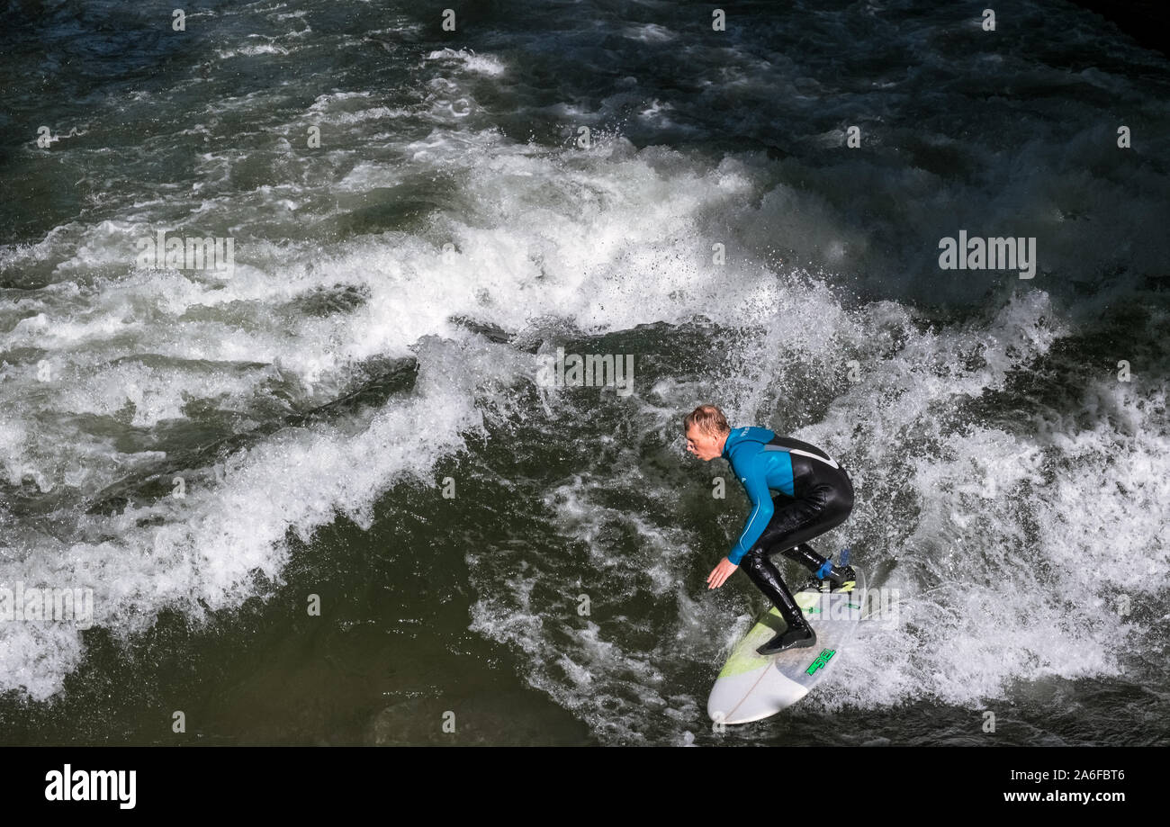 Un internaute chevauche la vague artificielle à Eisbachwelle, Munich, Allemagne. Partie d'une rivière, le spot est utilisée pour une compétition de surf annuelle. Banque D'Images