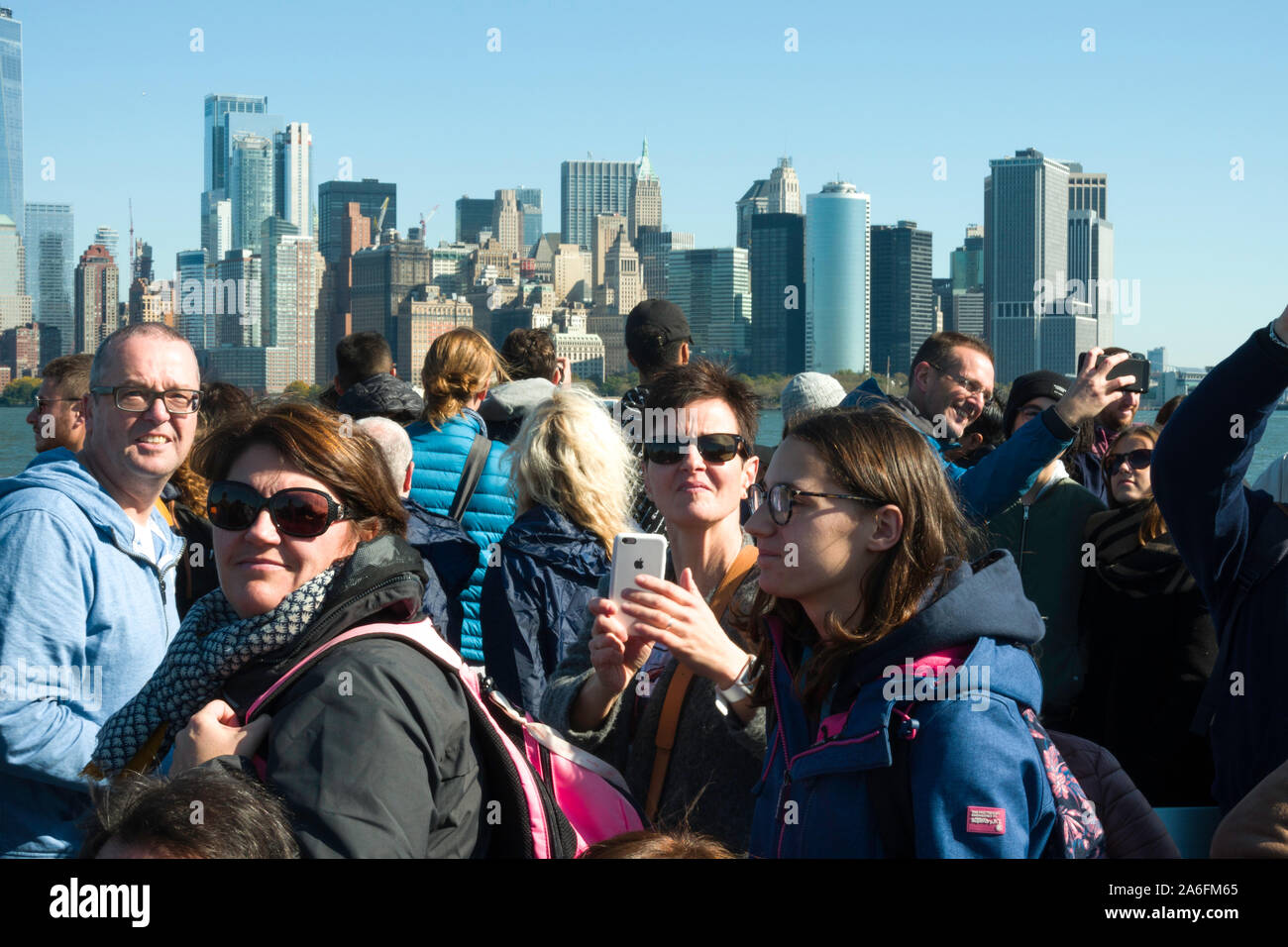Les touristes sur le ferry pour la Statue de la liberté de la prise de photos, NYC, USA Banque D'Images
