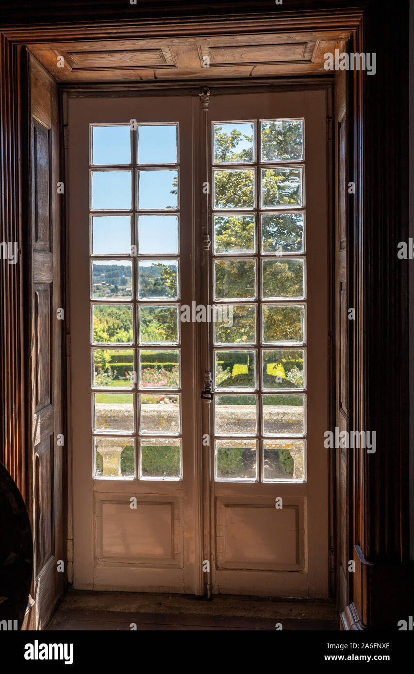 Et en bois sculpté portes vitrées menant de vieille maison en jardin avec du soleil Banque D'Images