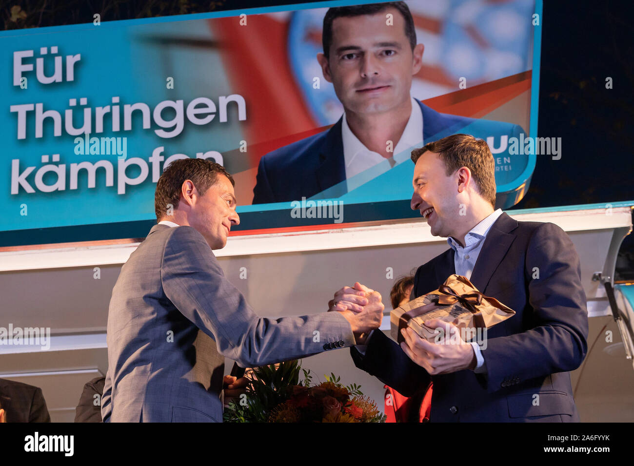 Erfurt, Allemagne. 26Th Oct, 2019. Mike Mohring (l), CDU le premier candidat pour les élections de l'état, reçoit un présent à partir de la CDU Secrétaire Général Paul Ziemiak avec quelque chose de 'sweet' à la fin de la campagne électorale de la CDU de Thuringe sur l'Wenigemarkt. Crédit : Michael Reichel/dpa/Alamy Live News Banque D'Images