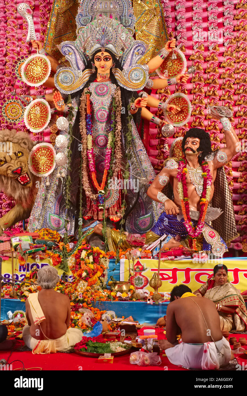 Au cours de la fête hindoue de Durga Puja à Mumbai, Inde, les prêtres s'asseoir devant une grande statue de Durga et autres chiffres hindous pour effectuer les rituels Banque D'Images