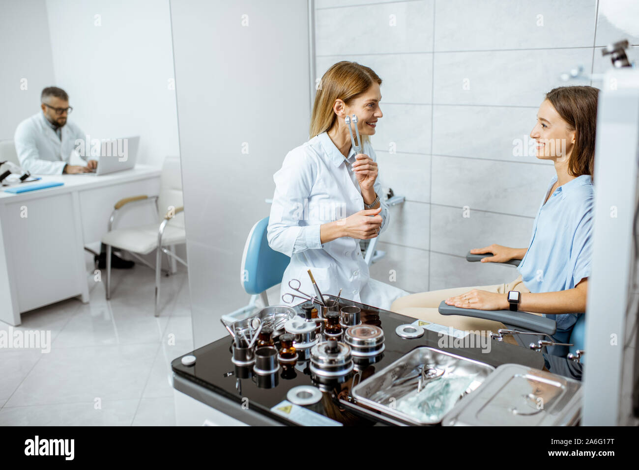 L'examen oto-rhino-laryngologiste femelle avec oreilles diapason ORL pour un jeune patient dans le bureau médical avec médecin sur l'arrière-plan Banque D'Images