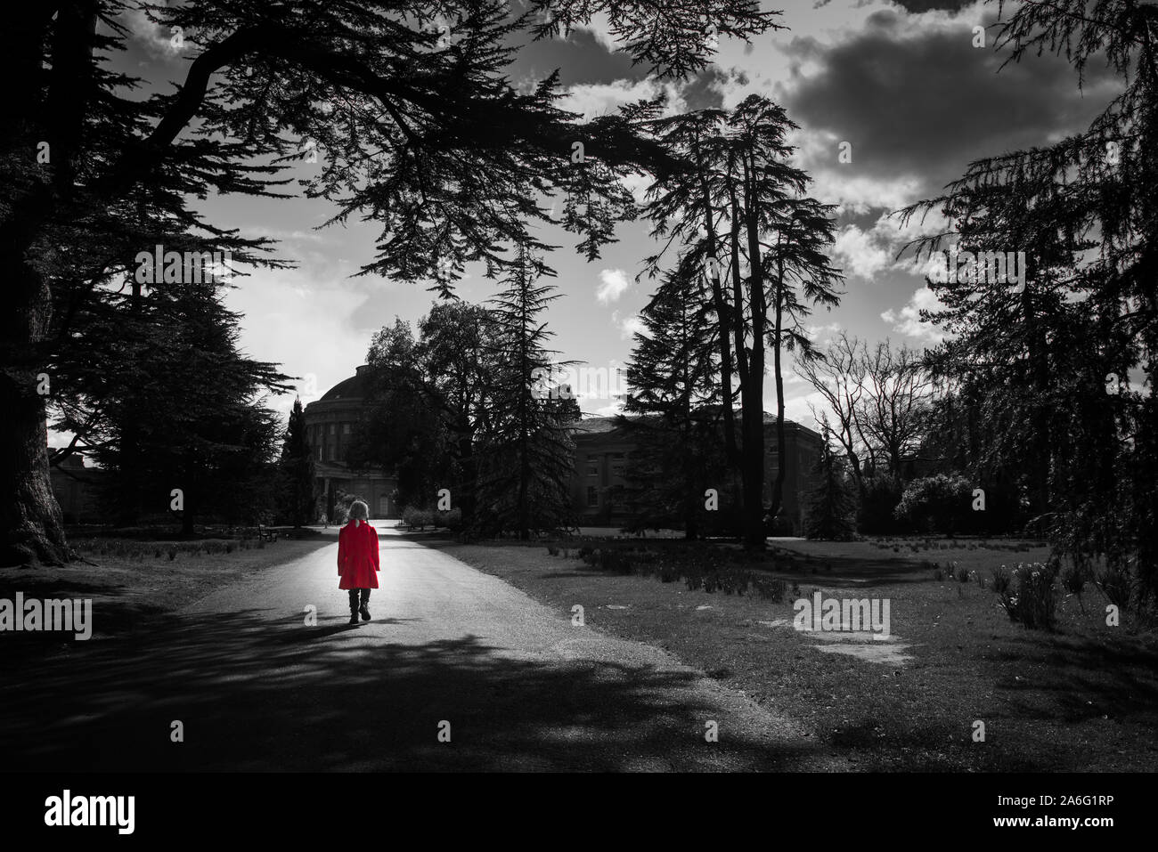 Une petite fille dans un manteau rouge à à Ickworth House sur une journée en famille, belle architecture et bâtiments historiques, isolé, seul, thoughful Banque D'Images