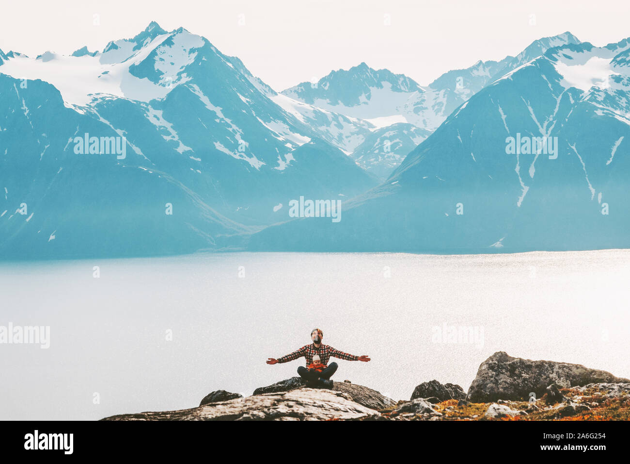 Père avec bébé yoga méditation dans les montagnes de vie familiale saine et de détente en plein air vacances voyage de l'harmonie avec la nature concept Banque D'Images