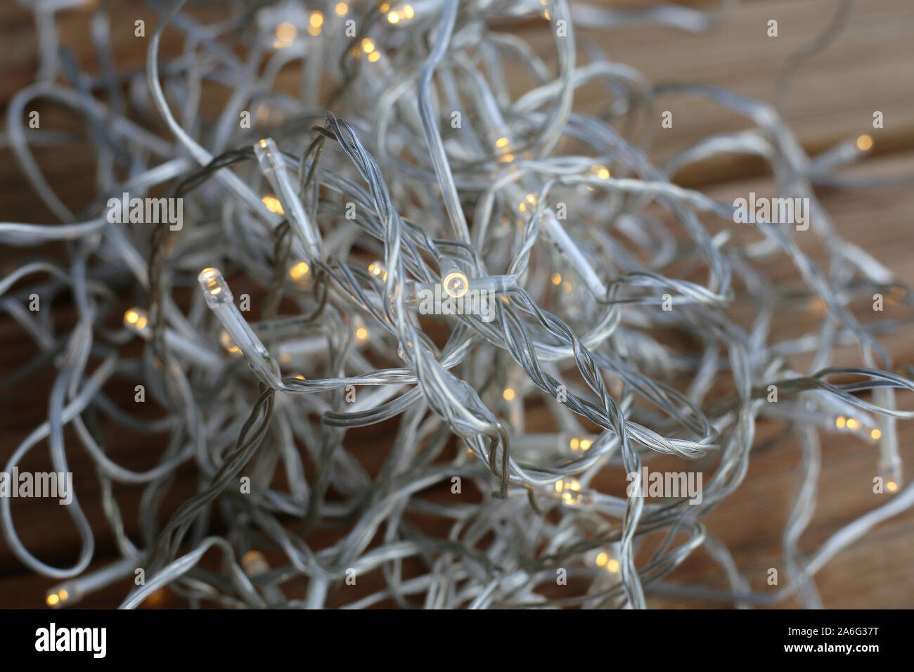 Lumière de Noël string tas sur un sol en bois. La chaîne est transparent et les lumières sont de petites ampoules led jaune. Led économe en énergie ! Banque D'Images