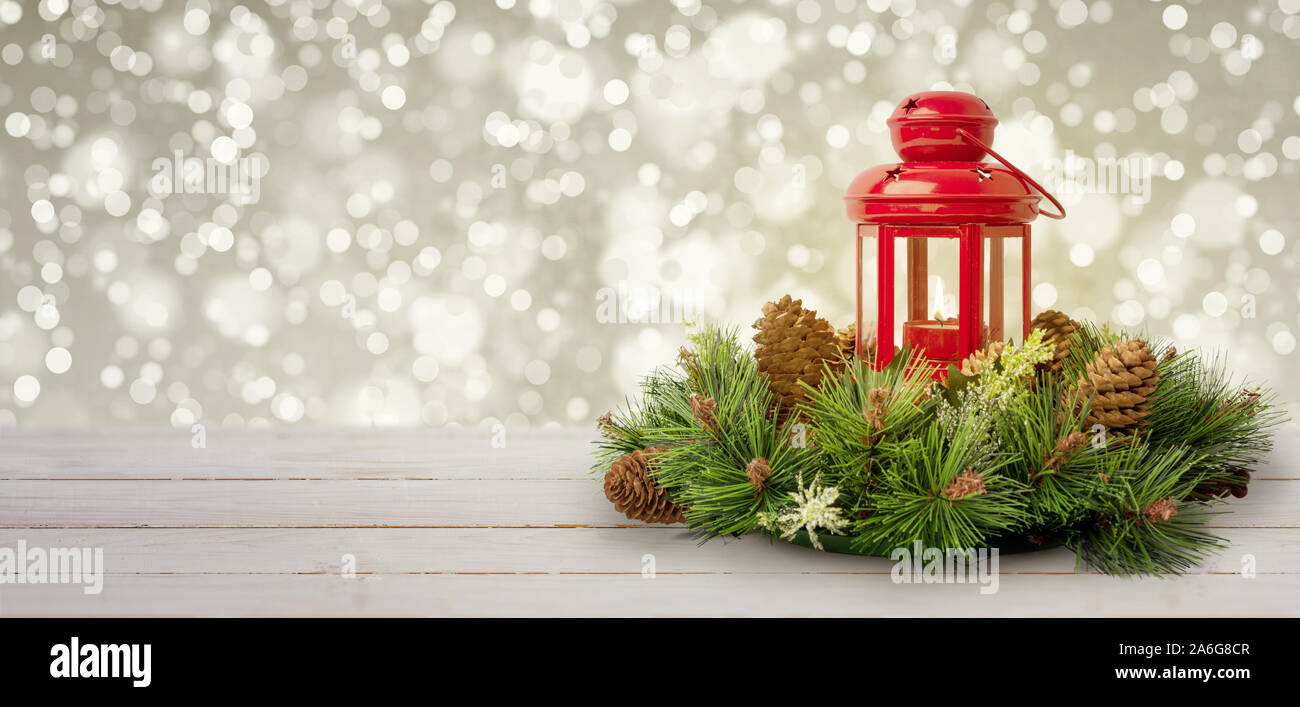 Décoration de Noël avec des branches de sapin, cônes et lanterne rouge sur le dessus. Table en bois blanc. Les lumières de Noël en arrière-plan. Copie espace à côté. Banque D'Images
