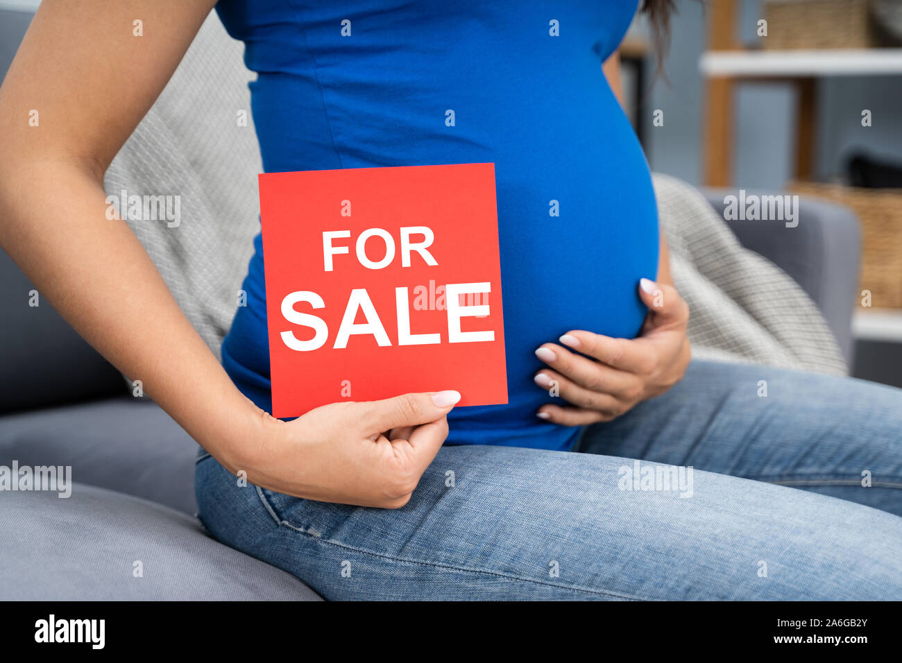 Jeune femme enceinte offrant son bébé à vendre Banque D'Images