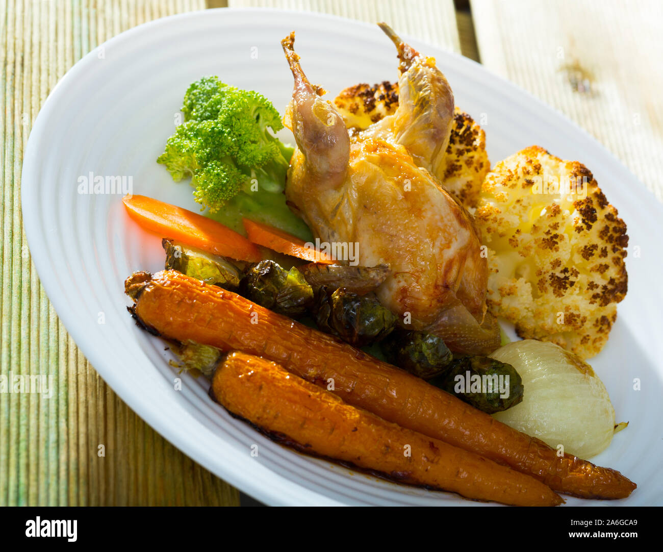 Caille délicieux grillés au four avec des légumes en sauce moutarde au miel  servi sur plaque blanche Photo Stock - Alamy