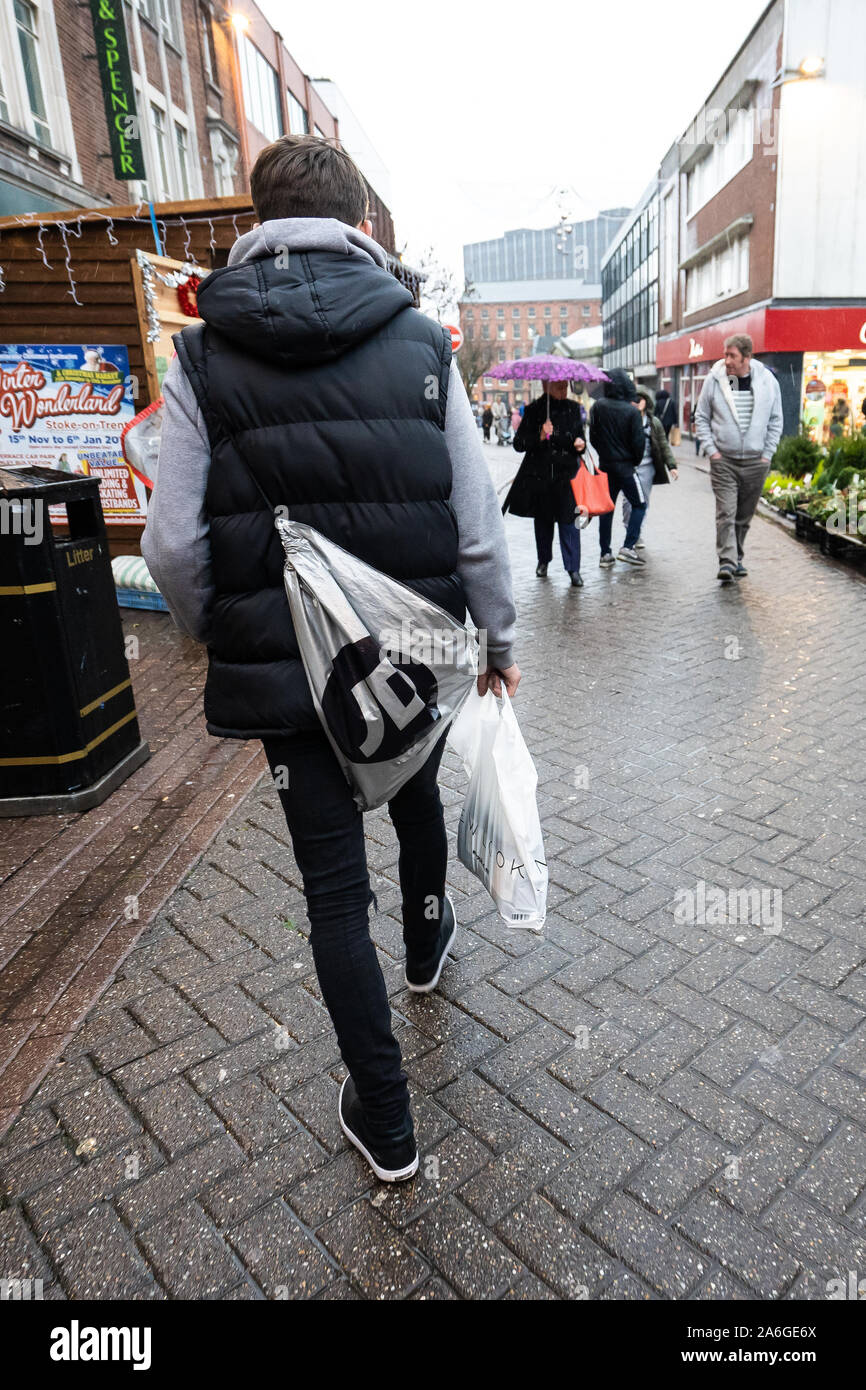 Un jeune homme portant un sac de sport JD promenades à travers le  centre-ville de Hanley, Stoke on Trent sur un jour pluvieux et froid en  hiver Photo Stock - Alamy