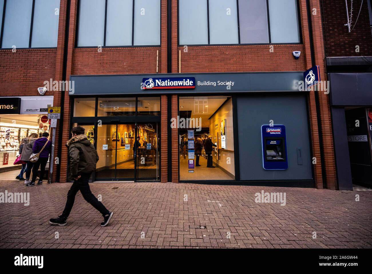 Une personne passe devant la Nationwide building society et la banque sur la rue principale et du centre-ville, Hanley, Stoke on Trent Banque D'Images