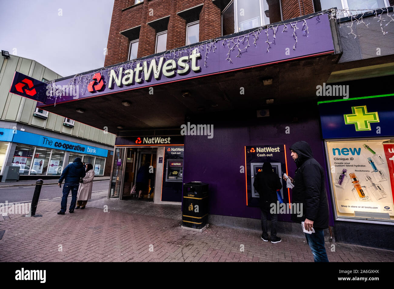 Les clients qui entrent et sortent de la Banque Natwest et en utilisant les billets sur la rue principale dans le centre-ville Banque D'Images