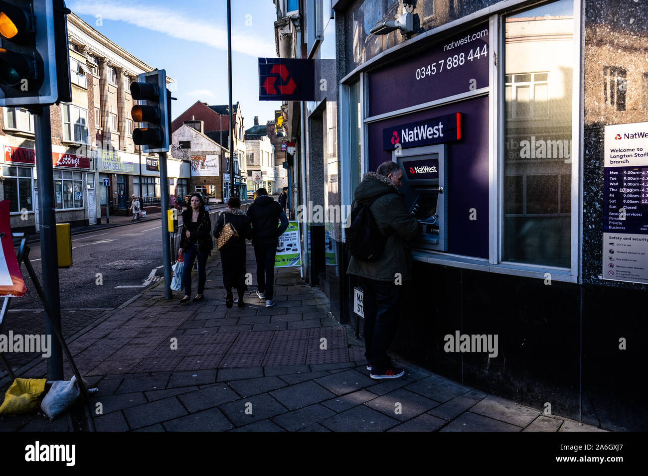 Un homme à l'aide de la Natwest cash machine, un distributeur de billets, distributeur automatique de billets pour retirer de l'argent sur la rue Banque D'Images