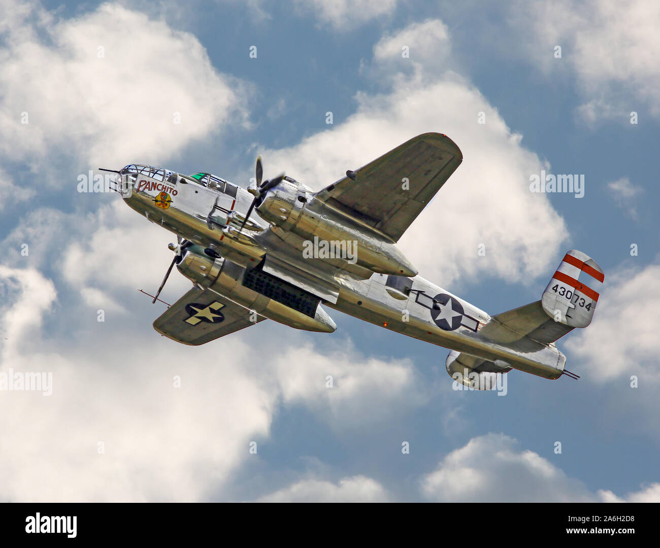 Une guerre mondiale II B-25 Mitchell bomber en vol avec bombay portes ouvertes contre un ciel partiellement nuageux. Banque D'Images