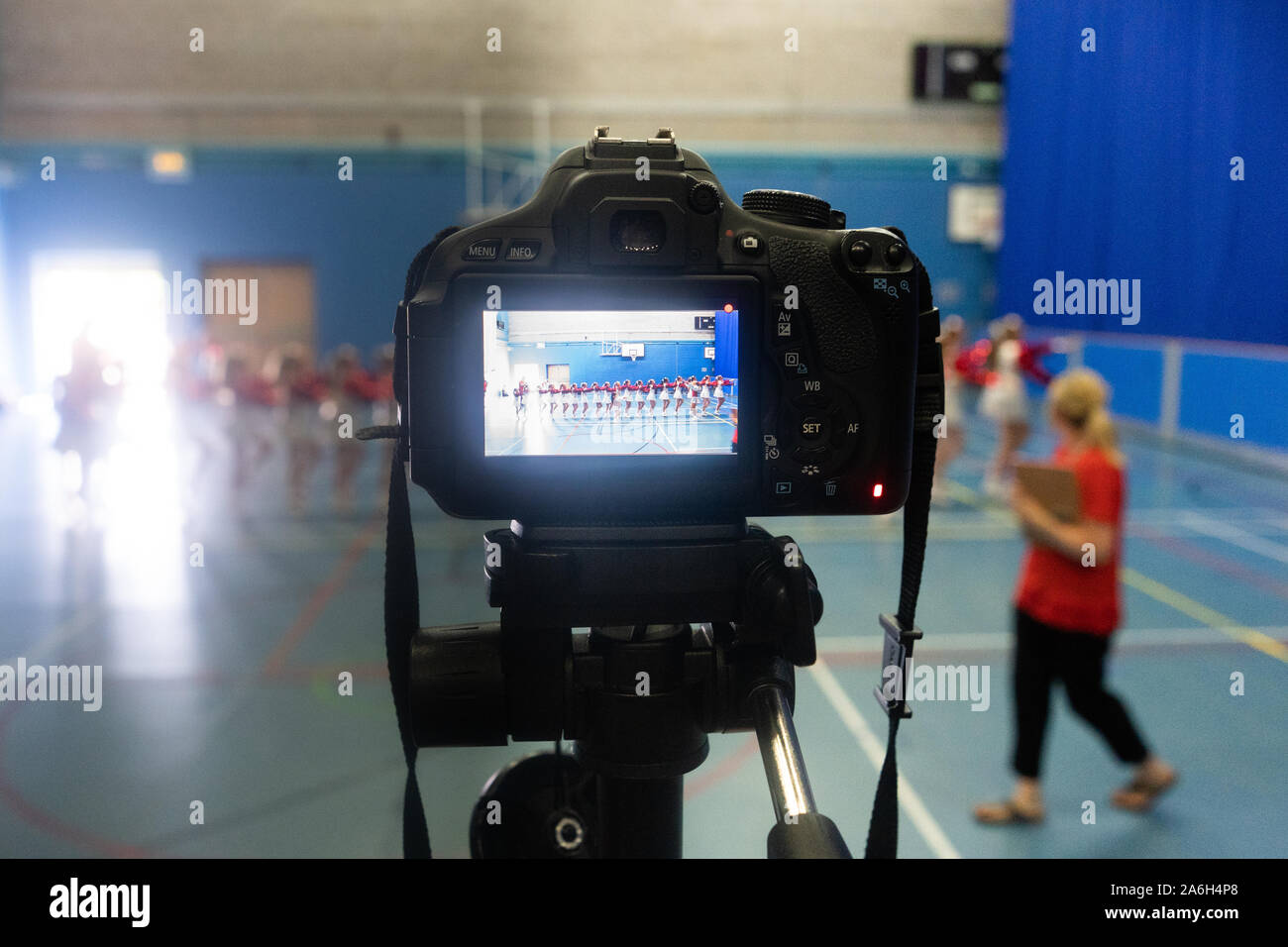 Un vidéographe enregistre un concours de danse jugé à un stade Banque D'Images