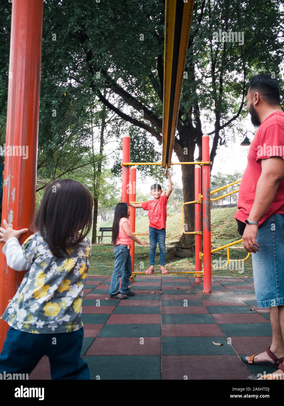 La famille asiatique jouant dans le Monkey bar jeux pour enfants le matin. Banque D'Images