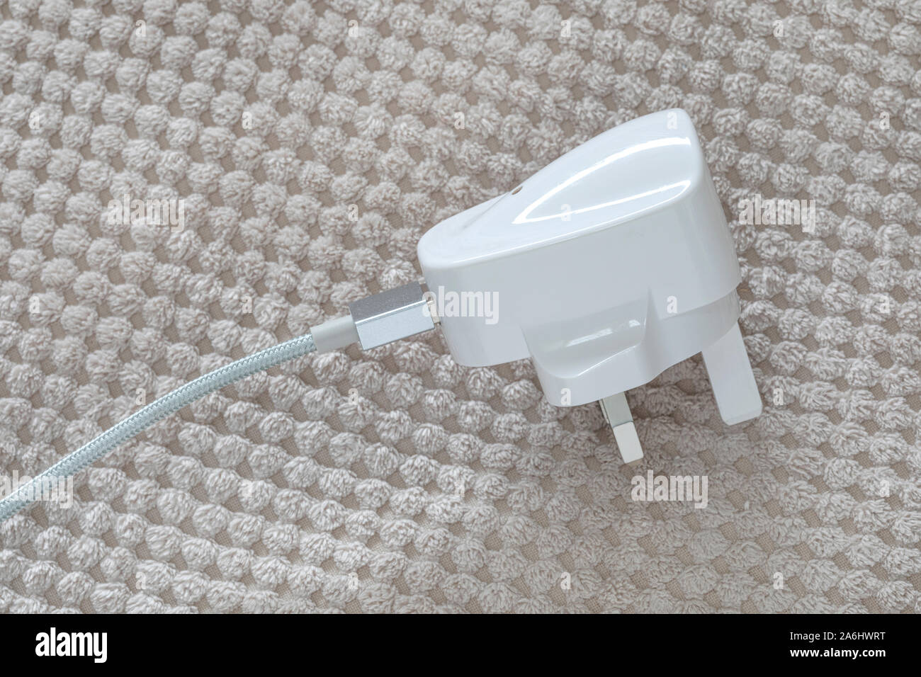 Fiche d'un ménage avec un câble du chargeur de téléphone Banque D'Images