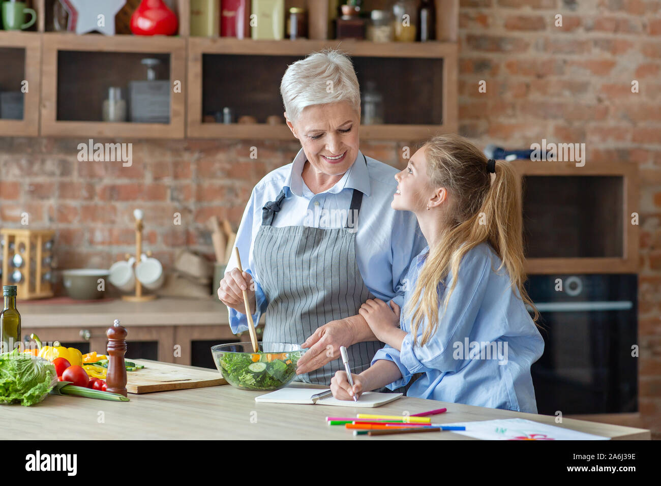 Vieille Femme montrant sa petite-fille comment cuisiner dans la cuisine Banque D'Images
