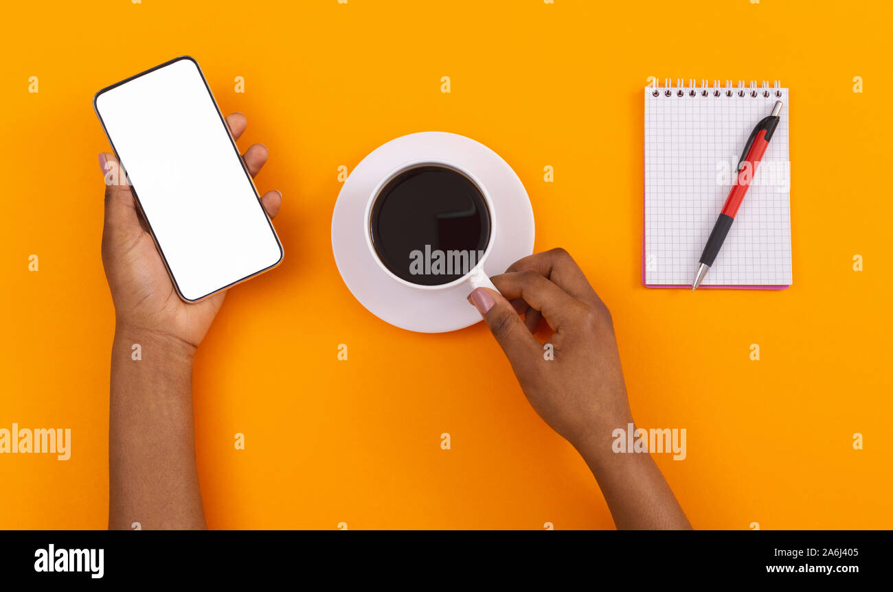 Woman's hands holding Smartphone avec écran blanc et Coffee cup Banque D'Images