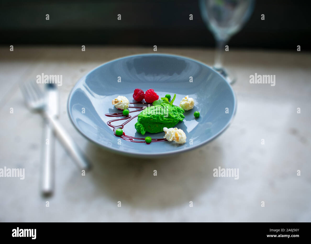 Sorbet menthe pois décoratifs avec des framboises et du popcorn avec arrière-plan flou Banque D'Images Sorbet menthe pois décoratifs avec des framboises et du popcorn avec arrière-plan flou Banque D'Images