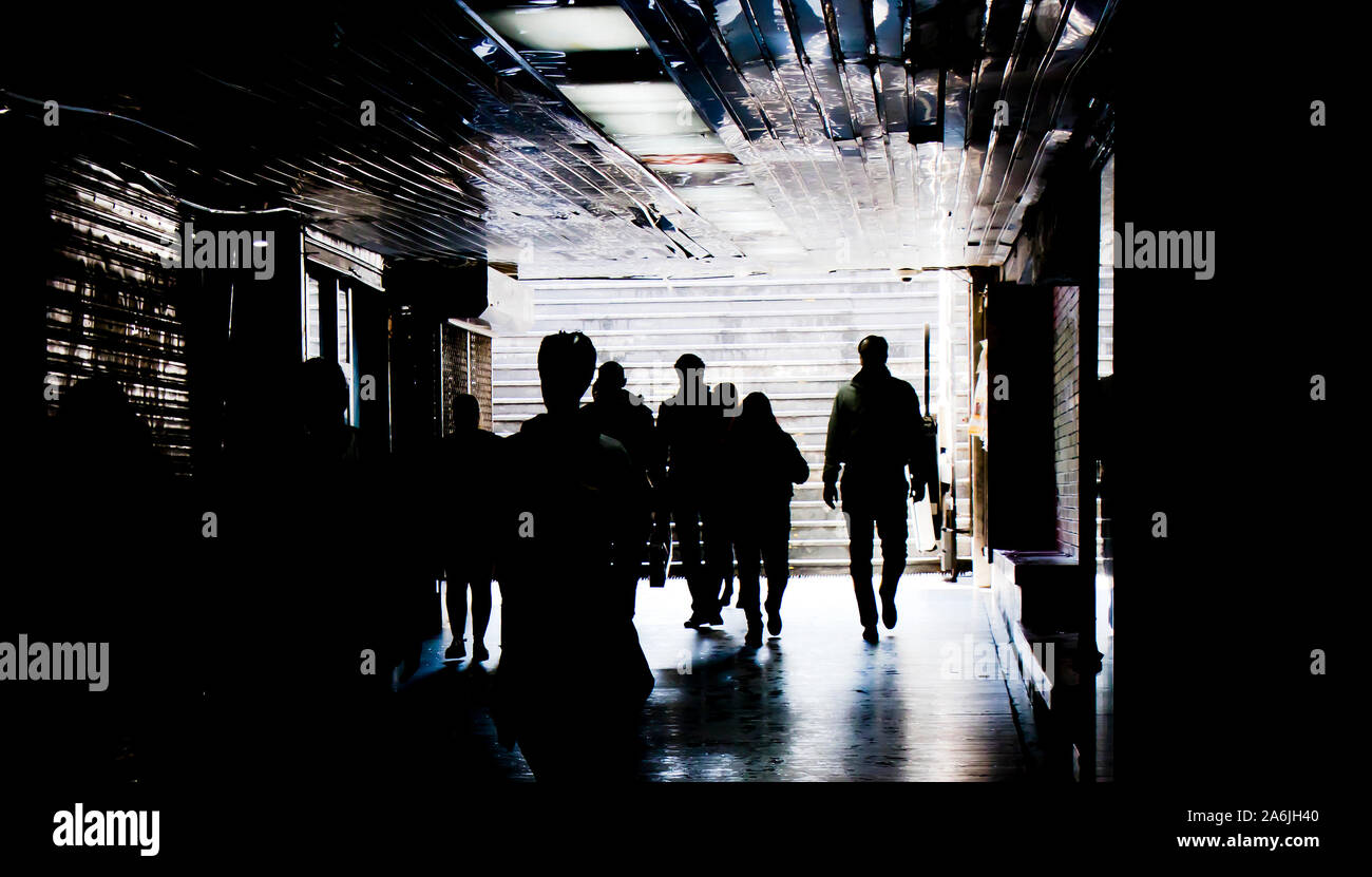 Les gens qui marchent dans le métro passage passage en noir et blanc à contraste élevé Banque D'Images