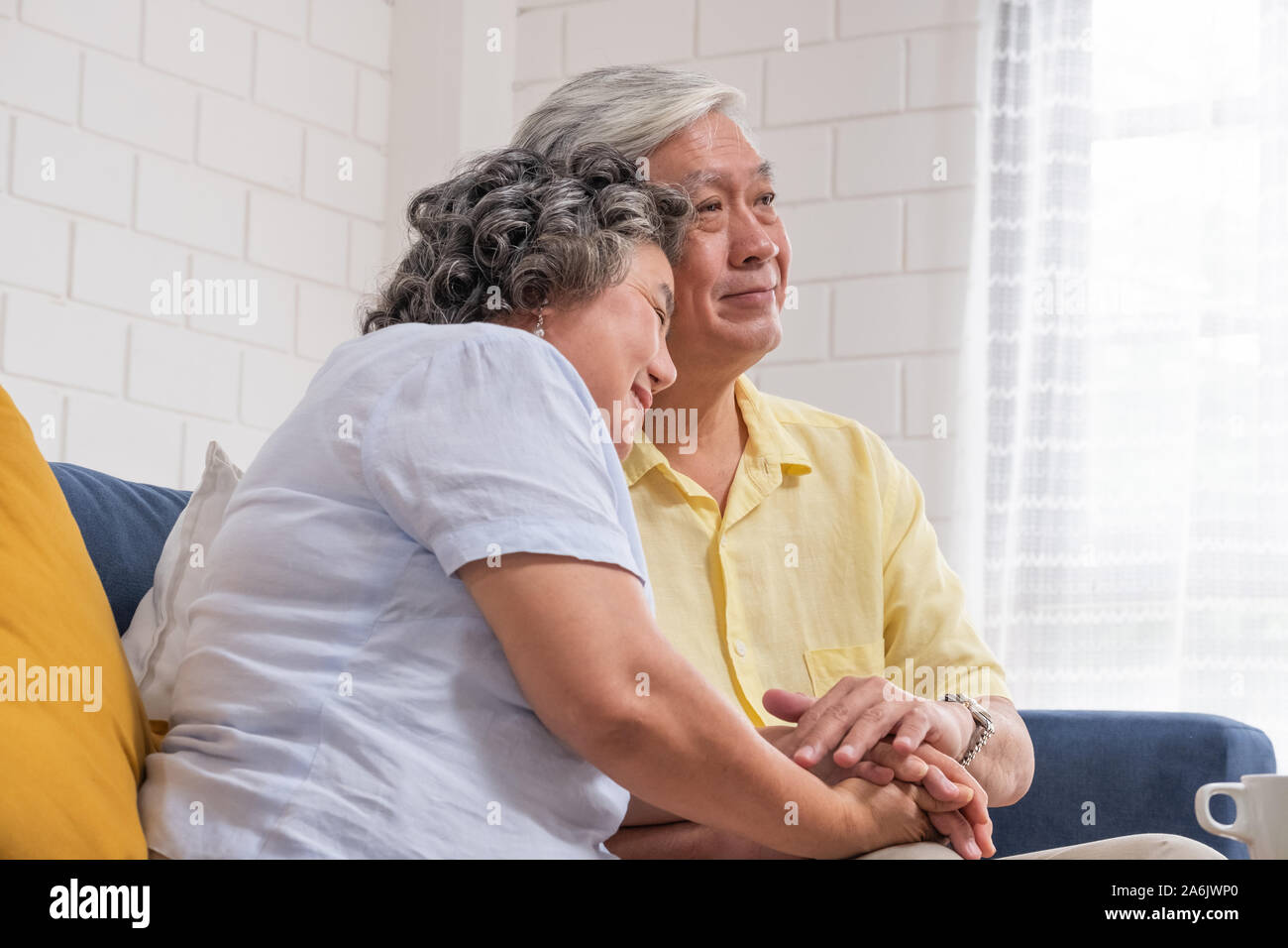 Close up Asian senior couple encourageant ensemble en maintenant l'autre main au canapé dans la salle de séjour à la maison.en toute sécurité avec une assurance vie à la retraite.le vieillissement à la maison Banque D'Images