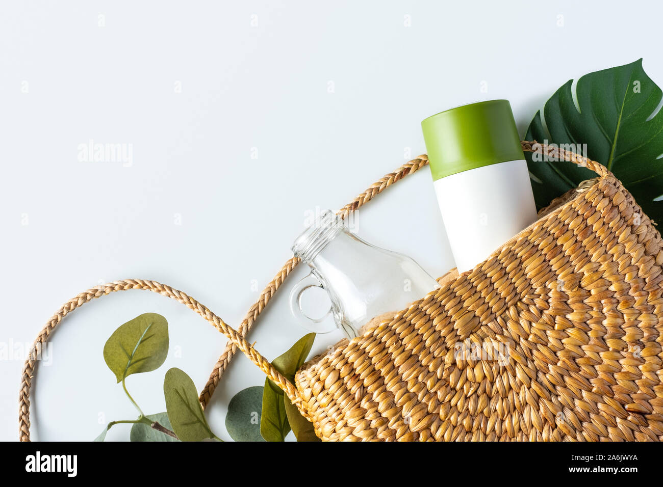 Zéro déchets concept.top view sac en osier avec bouteille en verre et tasse réutilisable avec feuille verte sur le tableau blanc.eco friendly pour l'environnement.de plastique Banque D'Images