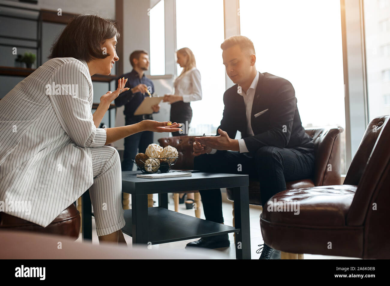 Jeune femme réussie dans un élégant costume élégant consulting un homme au travail. consultation gratuite, style de vie, temps libre, temps libre, travail, profession, oc Banque D'Images