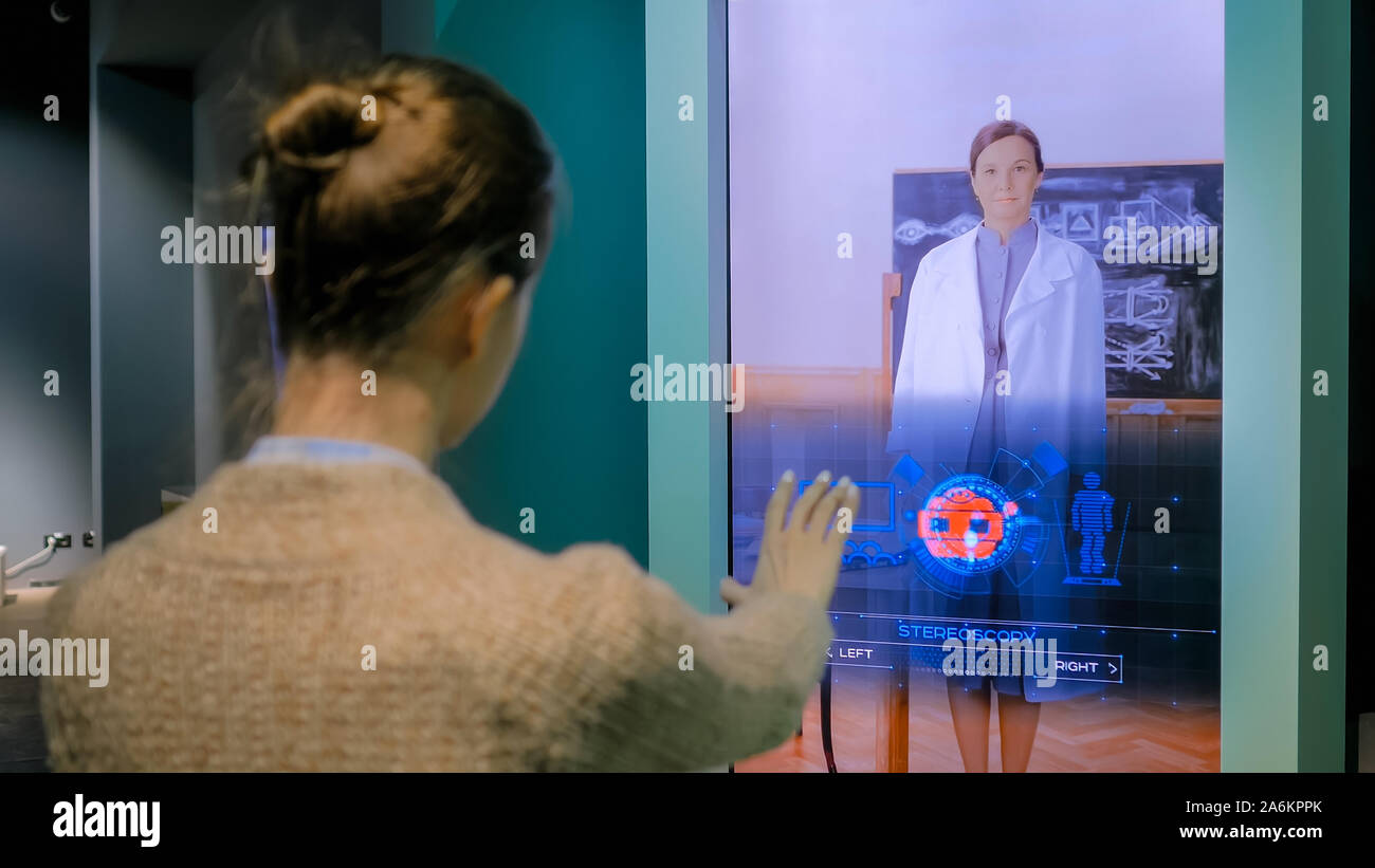 Femme à l'aide d'interactive kiosk affichage dématérialisé avec la technologie de commande gestuelle Banque D'Images