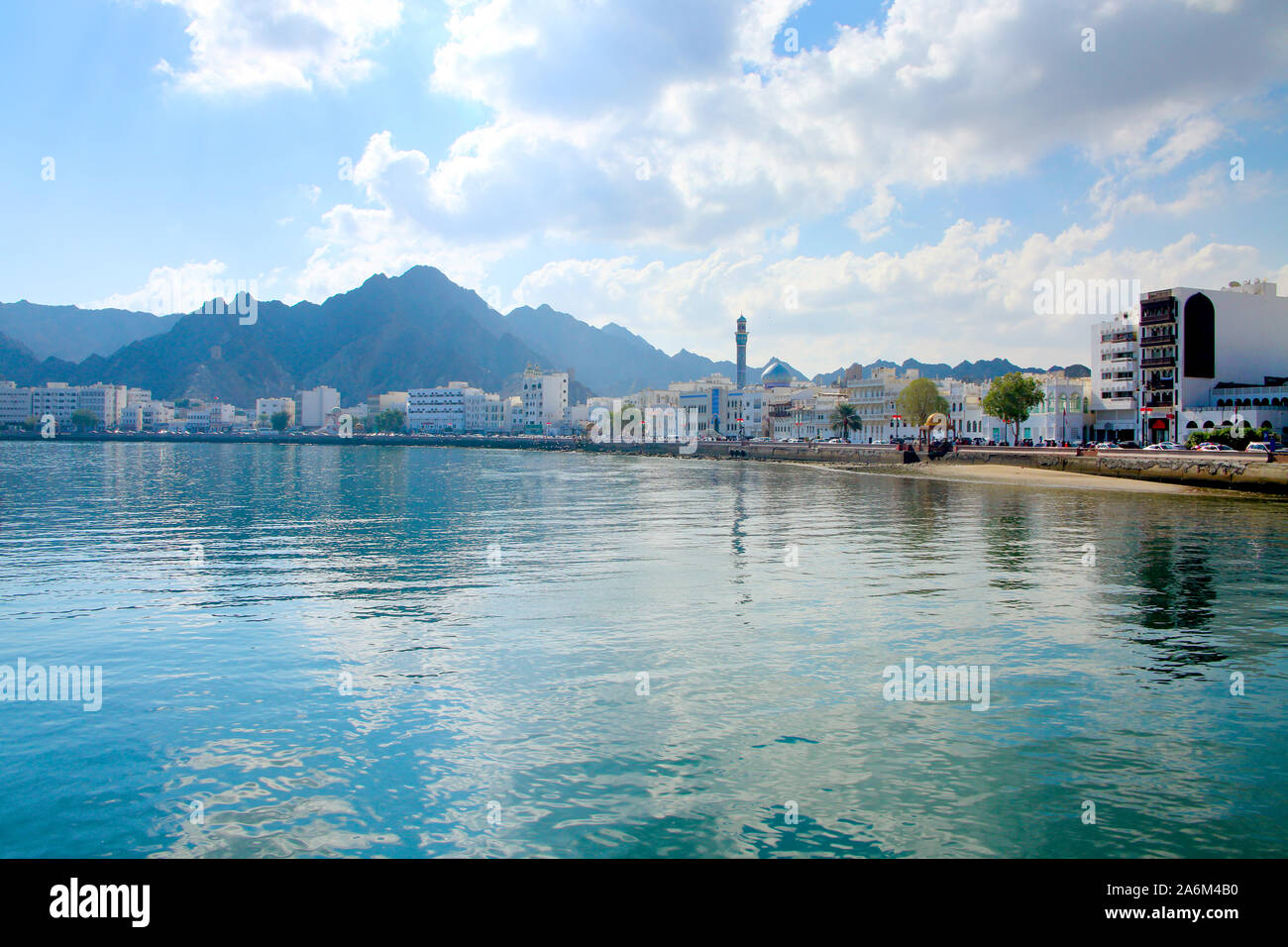 Bord de mer de la ville de Mascate, Oman, avec des bâtiments à l'avant-plan et entouré de montagnes derrière. Banque D'Images