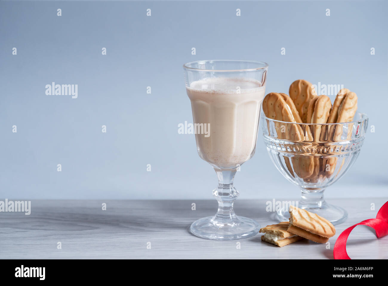 Poule dans des tasses en verre avec une mousse délicate, les épices et un bâton de cannelle Banque D'Images