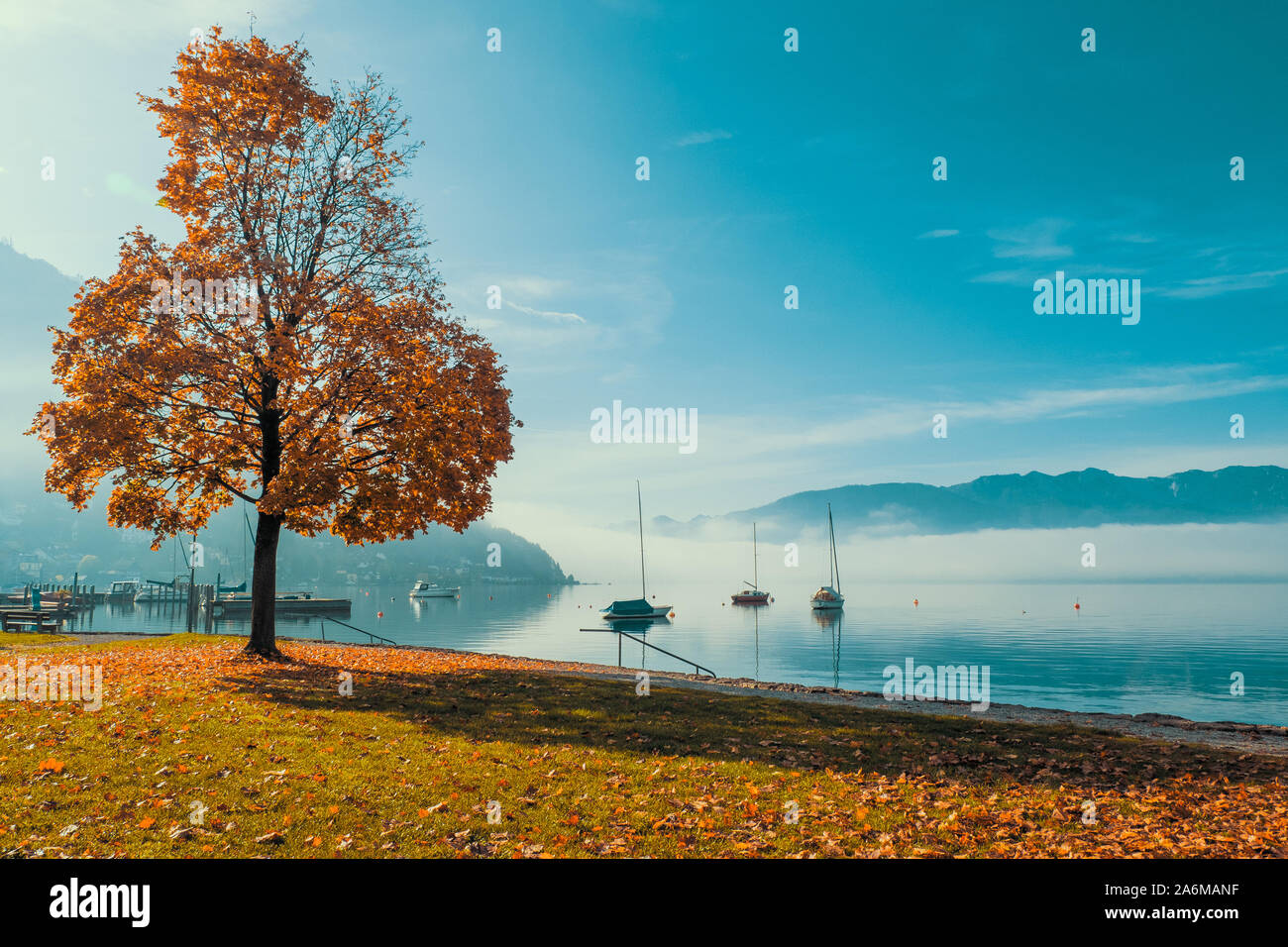 Vue en contre-jour des bateaux ancrés au Traunsee à Gmunden, en Autriche avec l'OÖ, Grünberg et l'augmentation de Traunstein en arrière-plan Banque D'Images