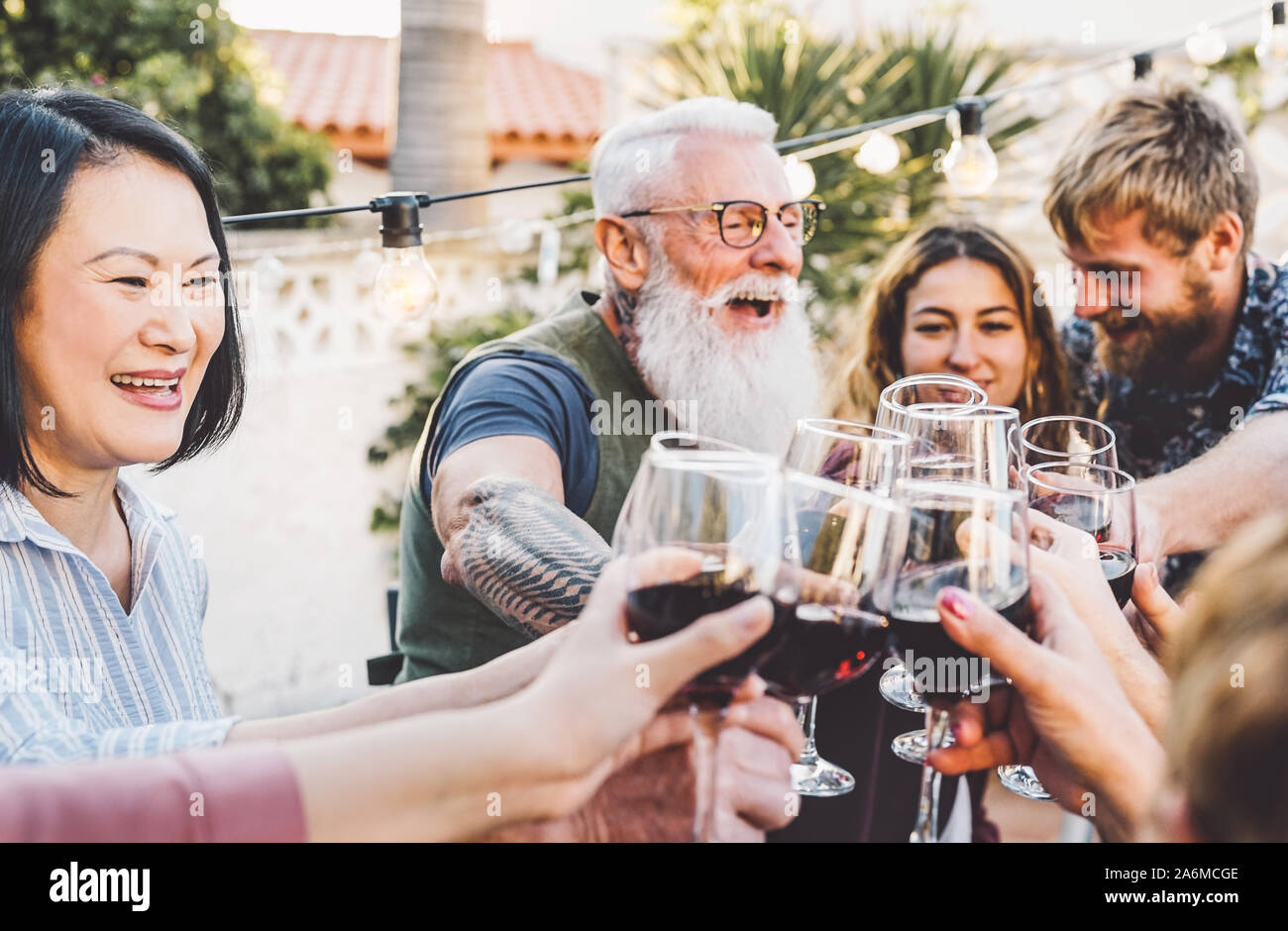 Happy Family cheering et grillage avec verres à vin au dîner en plein air - Les personnes atteintes de différents âges et de l'ethnicité s'amusant à bbq party Banque D'Images