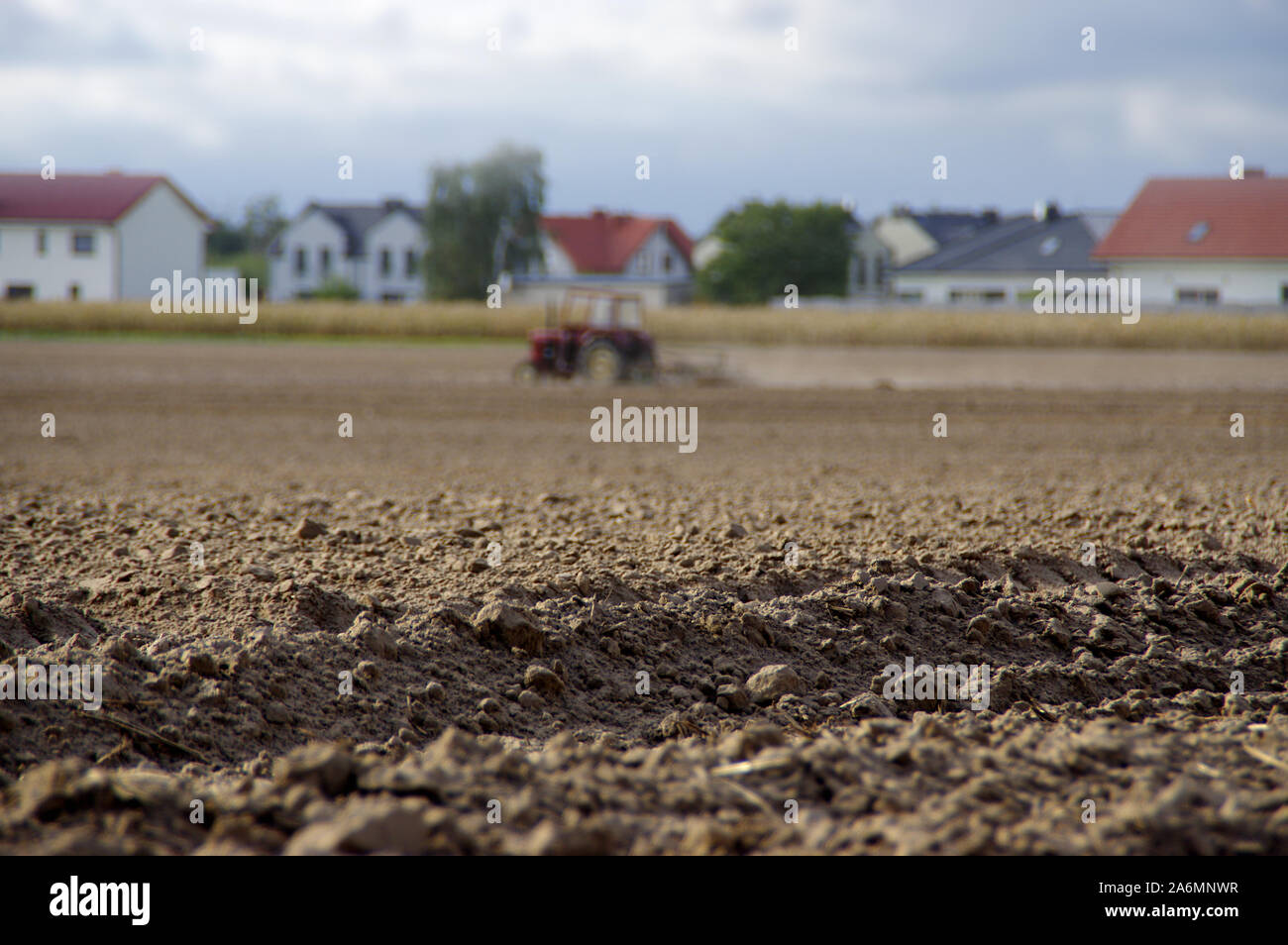 Agriculteur laboure la terre sèche avec un vieux tracteur en arrière-plan. La sécheresse, l'agriculture, travail du sol, de l'agriculture et de l'agriculture rural scene. Les pays européens Banque D'Images