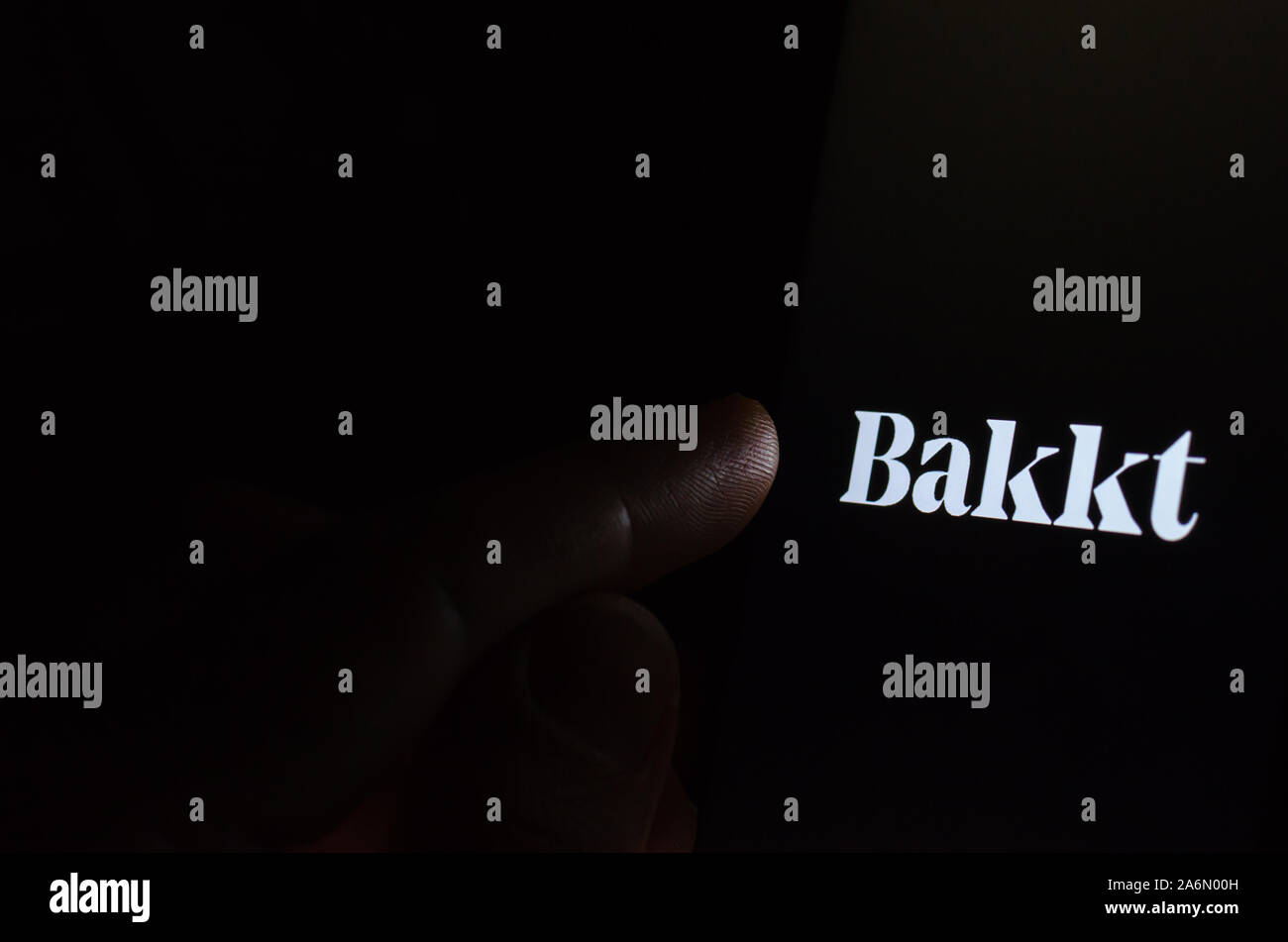 Logo de la société Bakkt sur l'écran du smartphone dans une pièce sombre et un doigt pointant sur elle. Bakkt Bakkt Bitcoin est connu pour des contrats à terme. Banque D'Images