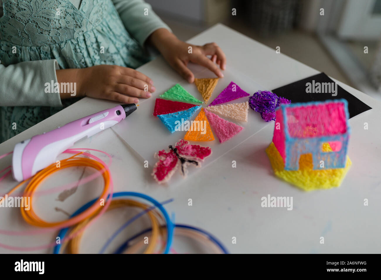 Cute little girl fait une maison en plastique, attire les pièces avec un stylo  3D. La vapeur et la tige de l'éducation. La modélisation, le développement,  l'éducation, de la conception avec le