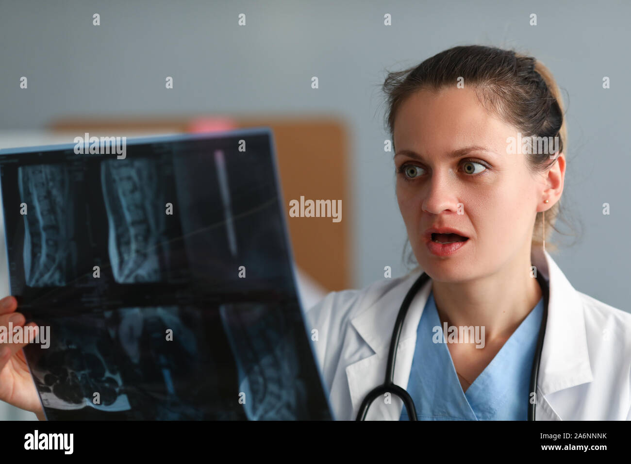 Excitée femme médecin tenir x-ray film dans la main contre Banque D'Images