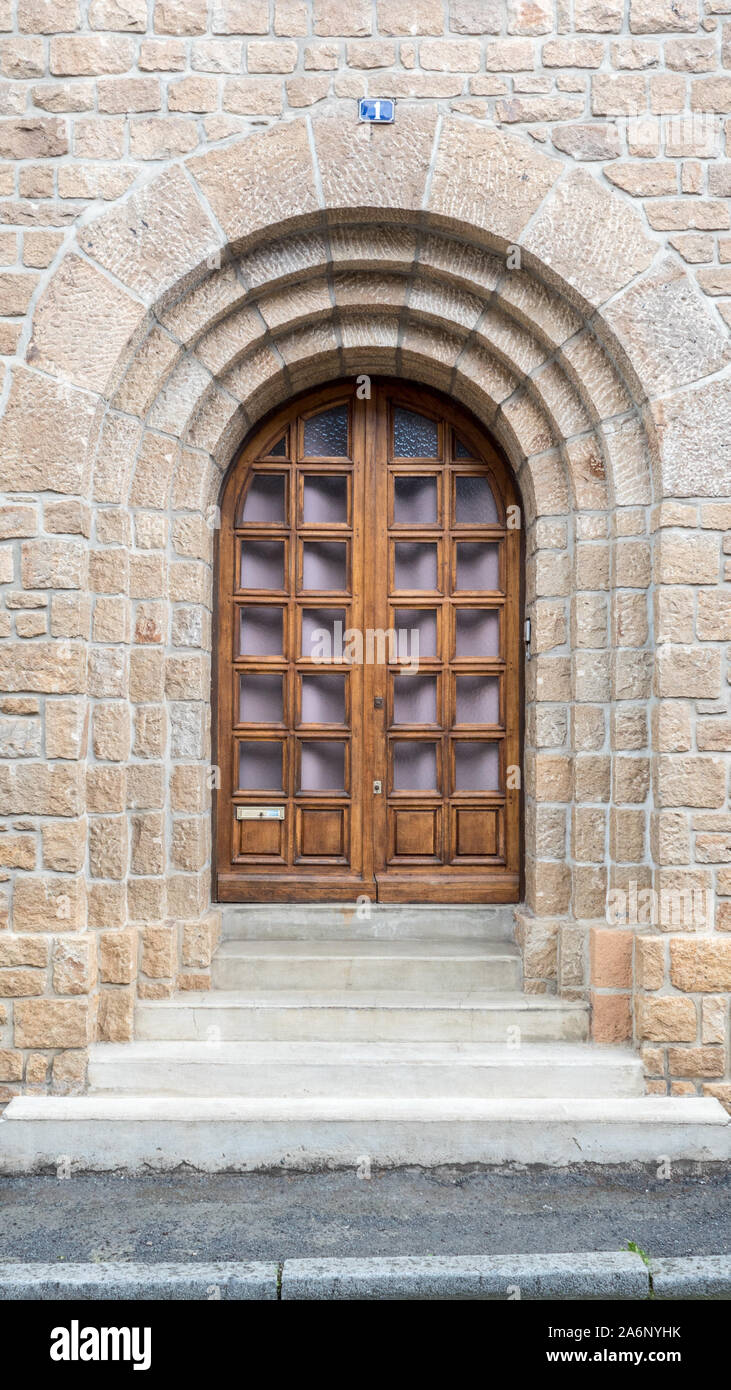 Belle et étonnante d'encadrement de porte en pierre ancienne, motif caractéristique de Normandie, porte en bois, en verre carré, demi-tour sur le dessus. Numéro de porte Banque D'Images