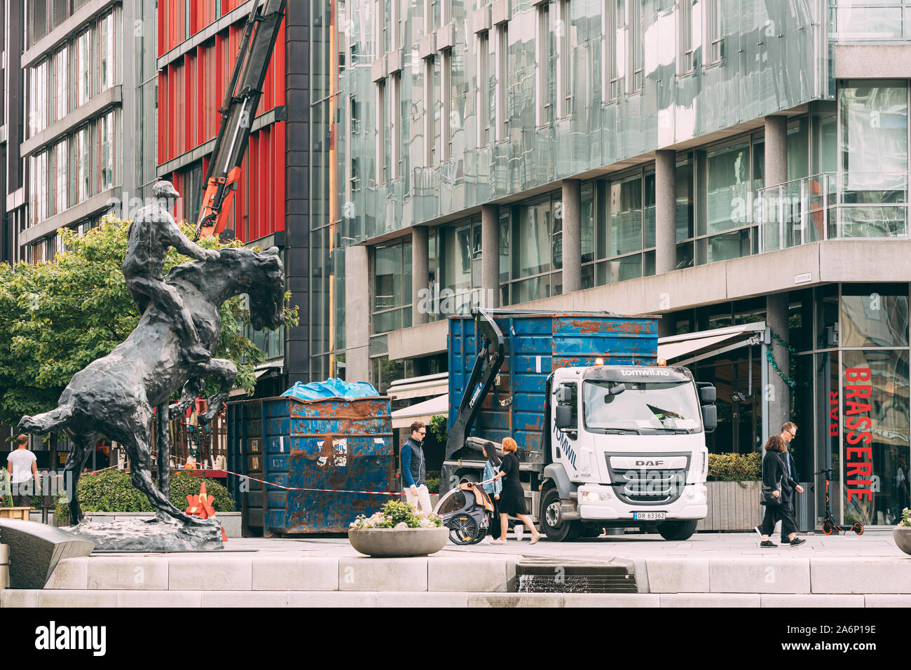 Oslo, Norvège - 24 juin 2019 : Chariot prend les déchets de construction résidentielle près de maisons à plusieurs étages dans quartier Aker Brygge. Banque D'Images