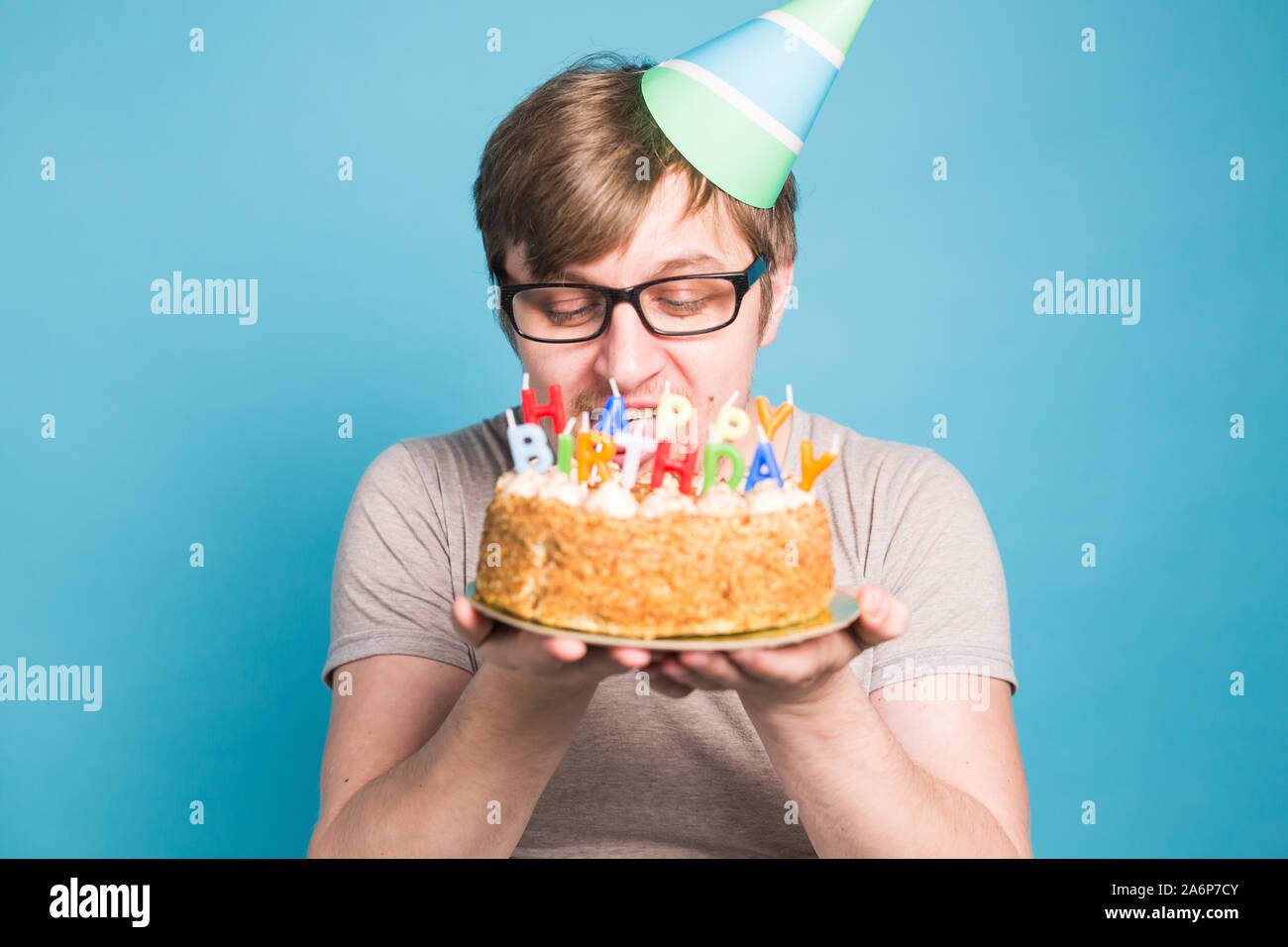 Jeune Homme Drole Fou Dans Les Verres Et Papiers Chapeaux Felicitations Joyeux Anniversaire Gateaux Tenant Debout Sur Un Fond Bleu Photo Stock Alamy