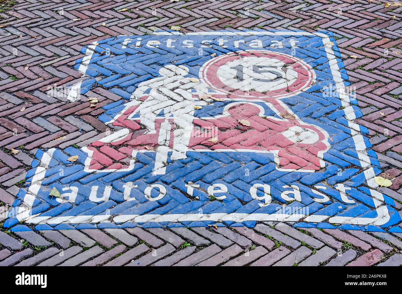 Le concept d'un vélo hollandais street dans lequel les voitures sont invités, a expliqué avec décoloration légèrement la peinture sur un trottoir de brique Banque D'Images